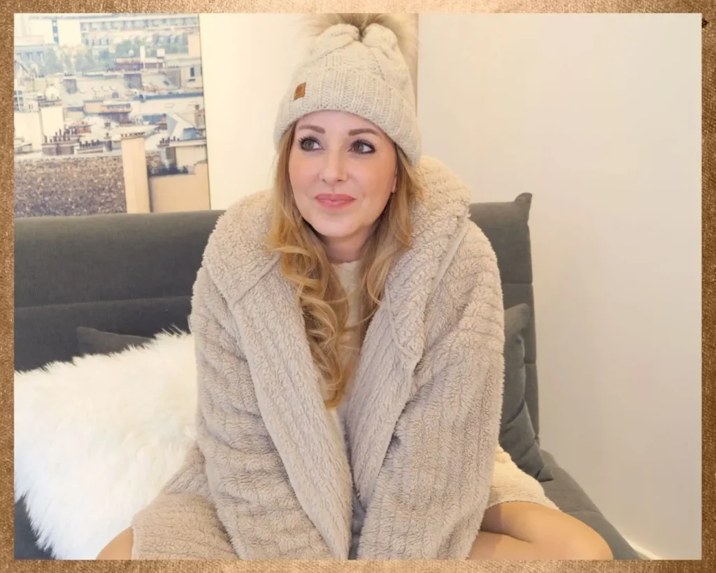 Frau sitzt entspannt auf einem Sofa und verkörpert kreatives Arbeiten zwischen Beauty, Alltag und digitaler Arbeit