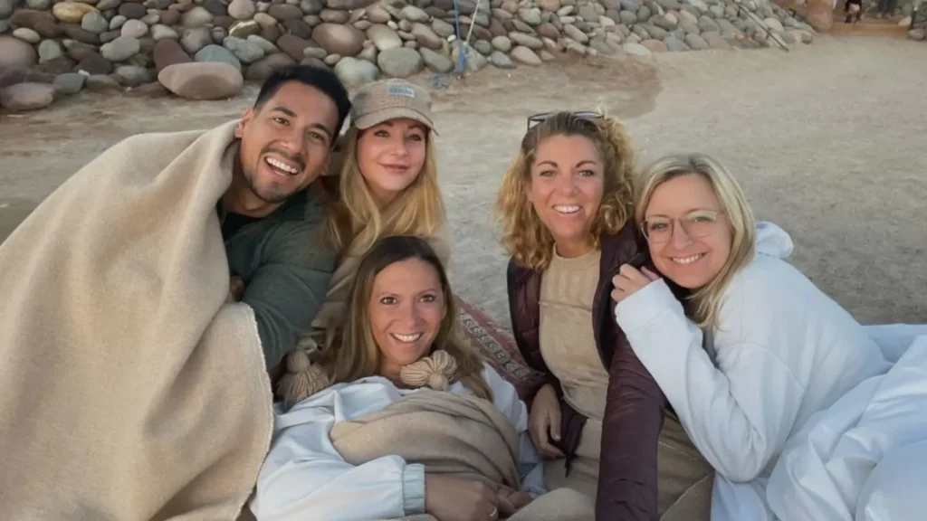 Gruppe von Berufstätigen bei einer Workation in der Wüste - hybrides Arbeiten zwischen Reisen, Austausch und Fokus