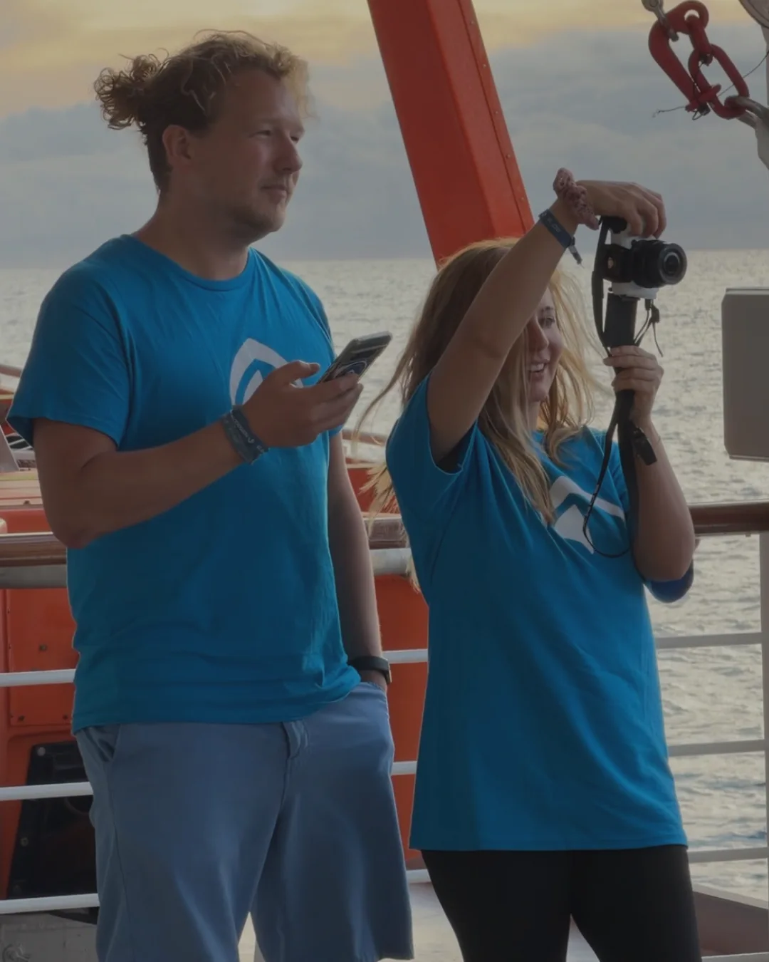 Zwei Content Creator bei der Arbeit mit Kamera und Gimbal auf einem Schiff - authentischer UGC Content für Reiseveranstalter